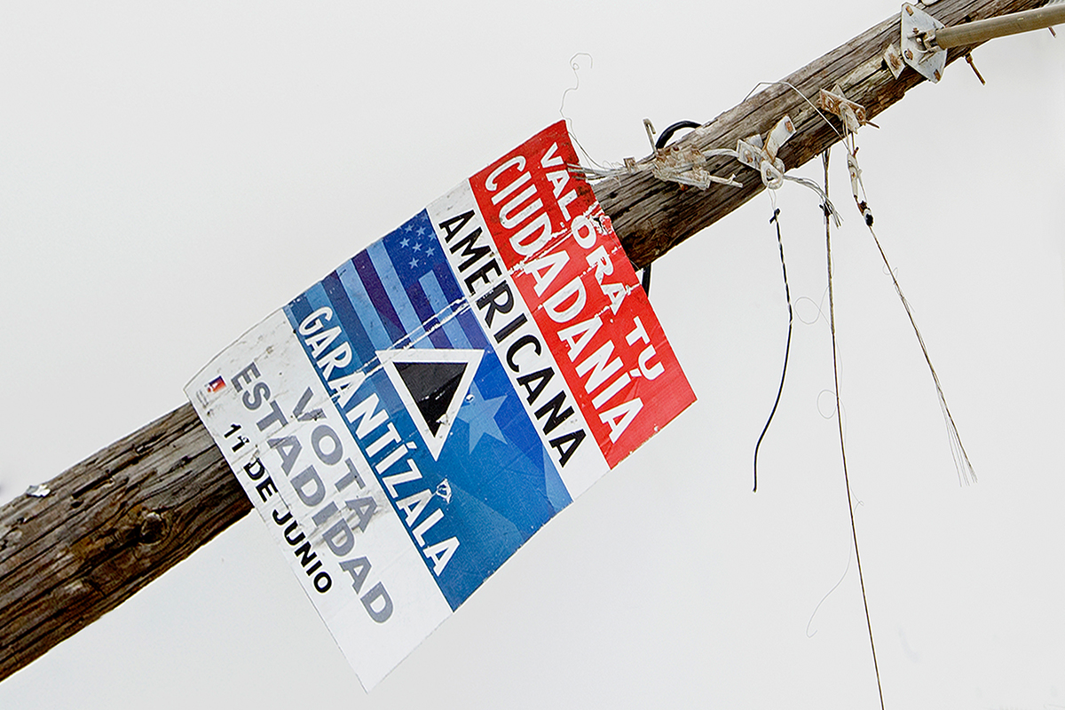 A broken wooden pole with a poster advertising elections in Spanish.